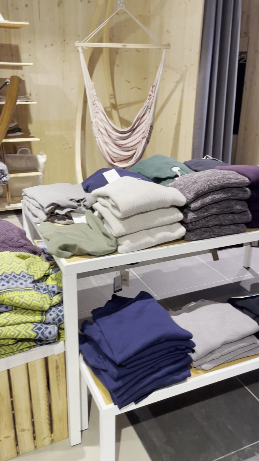 Gestapelte Pullover und Strickjacken im Weltladen Gmunden